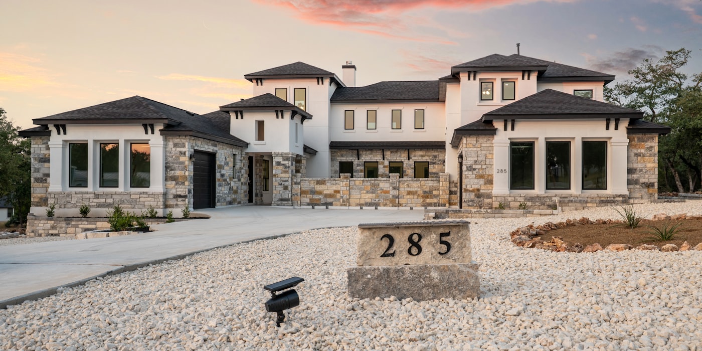 Beautiful stone and stucco home exterior at sunset in Texas